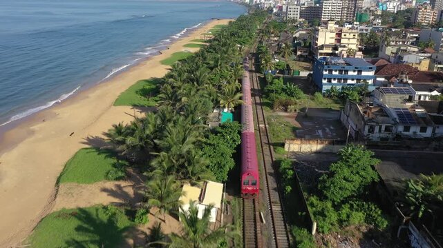 Cinematic Drone Shot of Coastal Train at Mount Lavinia Beach, Sri Lanka
