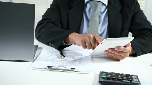Person scrolling on smartphone while reviewing financial information, Business records. Online tax filing, Digital documentation, Workflow management, Mobile productivity remote work concept