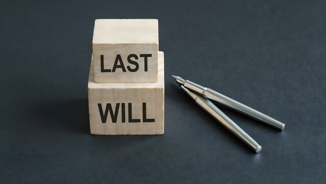 Wooden blocks with the words last will placed next to a metal pen