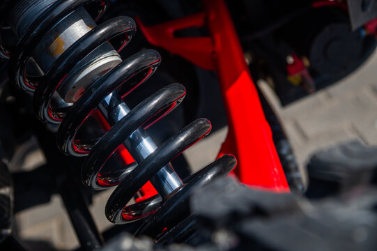 Close-up of automotive coil spring and suspension components in vehicle