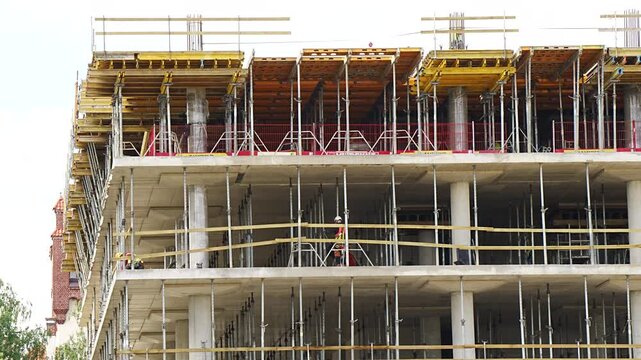 Reinforced concrete slab construction site showcasing H20 wooden beam formwork systems and telescopic steel jacks supporting a newly poured floor