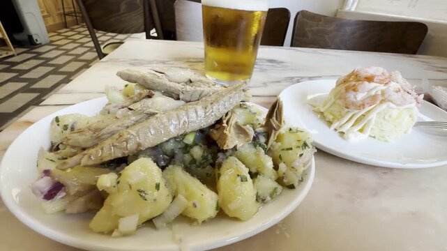 Spanish tapas with frigate mackerel potato salad and Russian salad served with beer