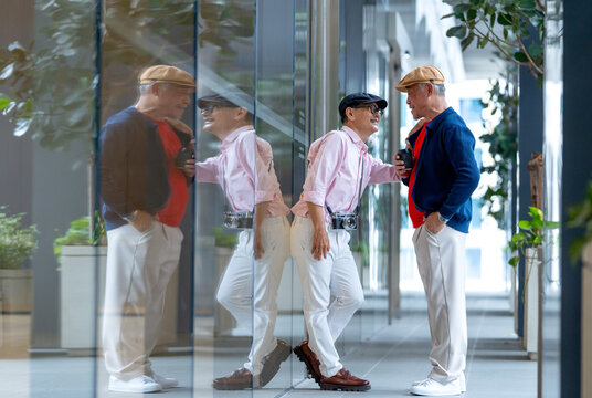 One Asian senior man look like lgbt touch and lean with the other man in front of glass wall to express happy in love.