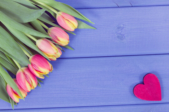 Bouquet of tulips and red heart on boards, symbol of Valentines Day, place for inscription