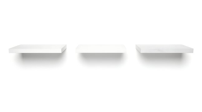 Three empty white shelves mounted on a white wall with shadows.