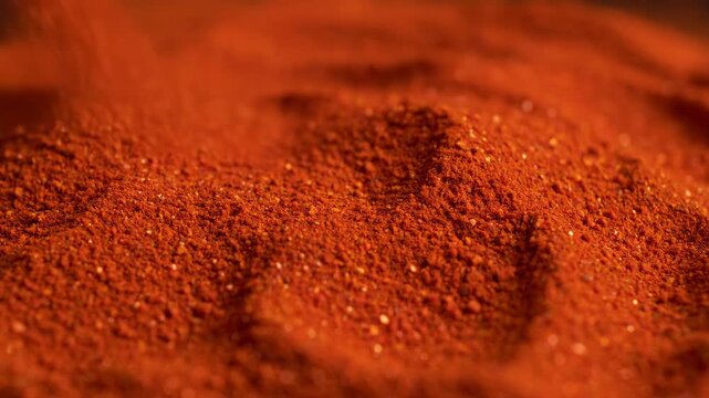 Macro Pouring Smoked Paprika Red Spice Powder on Culinary Pile
