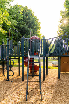Empty playground with slide and ladder backlit at golden hour