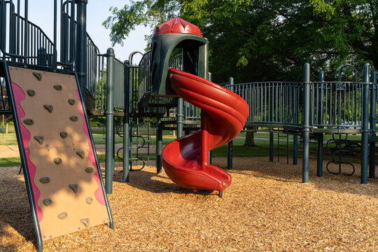 Playground climbing wall and spiral slide in morning sun