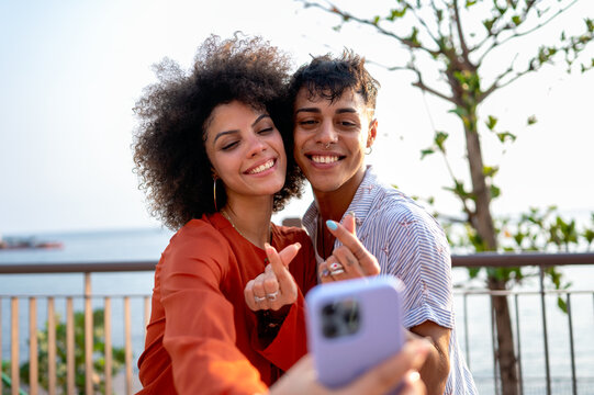 Young people capturing the vibrant urban tropical vibe, happily taking a selfie on a colorful street