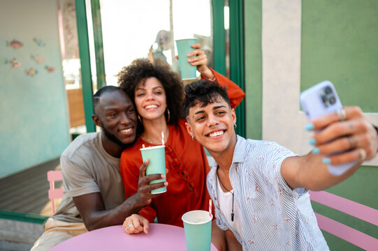 Multicultural group of friends relaxes together, enjoying fun, taking selfie, celebrating diversity