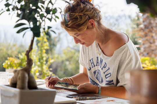 young woman artist working on a watercolor drawing outdoors