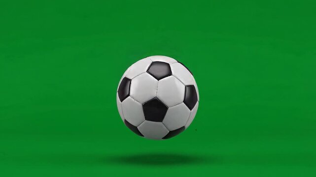 Football soars mid-air, classic design, bold black and white panels