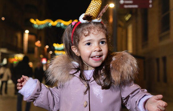 Happy little girl enjoying christmas holiday lights at night