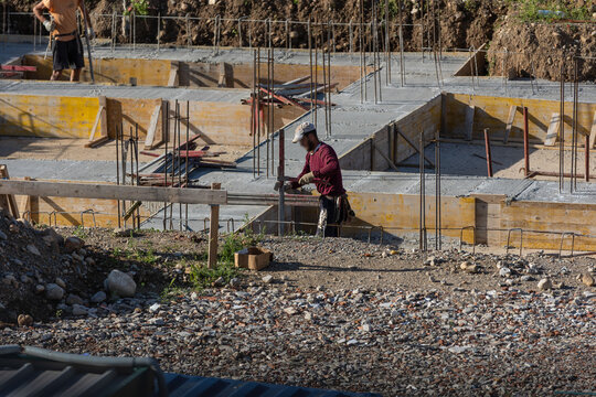 Construction Workers Pouring Concrete at Building Site During Foundation Work