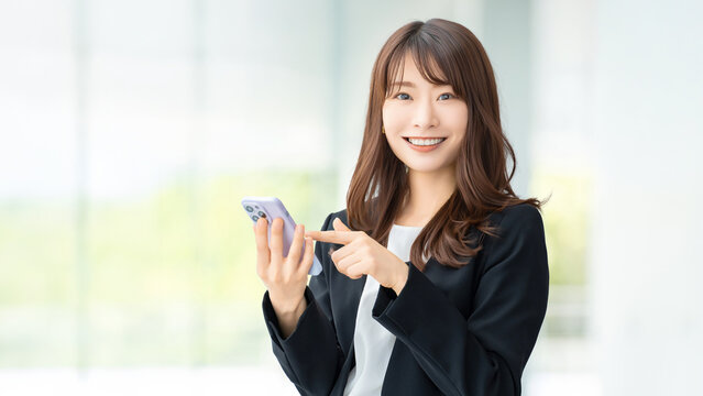 スマートフォンを使う笑顔の女性・ビジネスウーマン