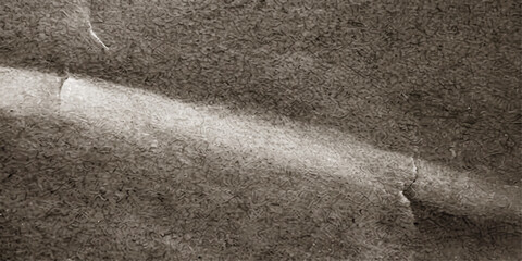 An abstract close-up of textured paper reveals a striking diagonal line of light, creating a dramatic interplay of shadow and highlight with a vintage feel. © QUALITY BOOST