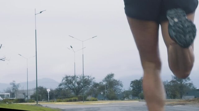 Female runner's legs passing speed limit sign with distant mountains on horizon