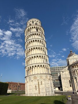 The Leaning Tower of Pisa rises majestically against a bright blue summer sky &mdash; one of the world's most iconic and beloved landmarks up close.