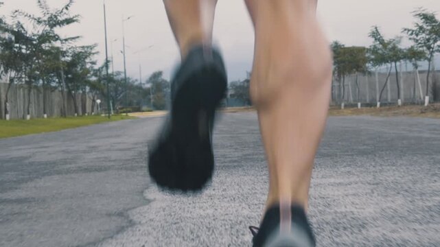 Close up of female runner's legs and sneakers near distant buildings