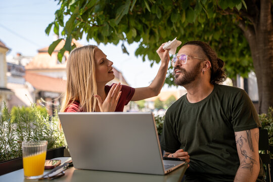 Freelancers man and woman relaxing in cafe garden during El Nino heat