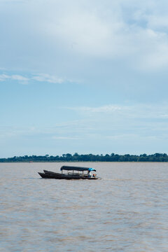 Motorboat on the Amazon River with a wooded area in the background.