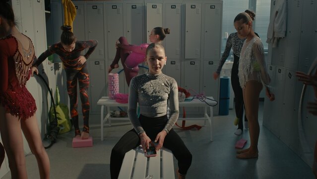 Teenage Rhythmic Gymnast Dealing With Severe Stage Fright and Psychological Pressure Before Tournament. Girl Turns on Playlist on Smartphone, Inserts Earphones, Shuts Eyes Tightly to Battle Anxiety.