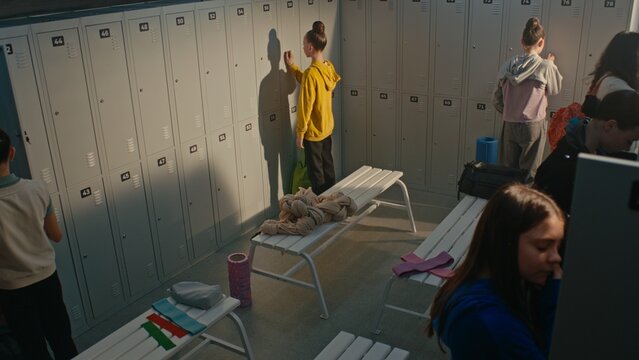 Group of Rhythmic Gymnasts Getting Ready in Busy Locker Room Before Practice. Girls Organize Sports Bags, Change Clothes and Prepare Equipment. Concept of Youth Sports, Teamwork, Athletic Preparation.