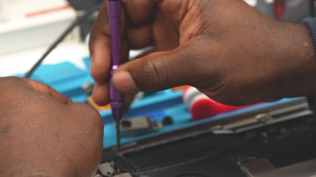 Detailed view of professional tech soldering electronic components on laptop circuit board closeup