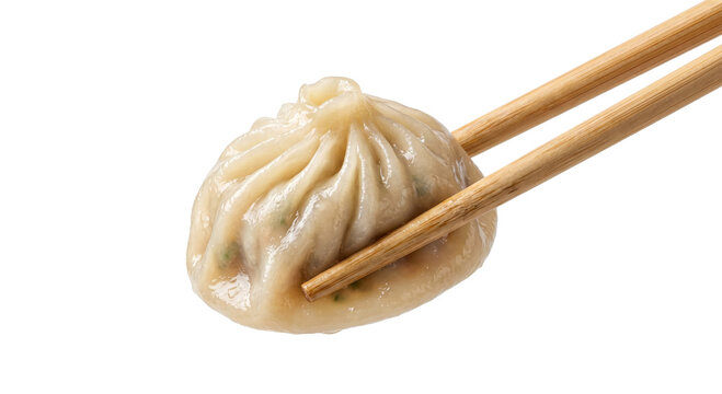 Steaming hot soup dumpling held delicately by bamboo chopsticks, ready to eat