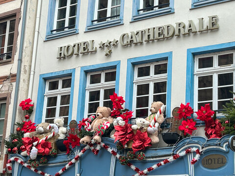Hotel building is decorated with teddy bears, wreaths and red flowers. Close-up. Strasbourg. France.