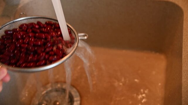 Red kidney beans rinsing and draining in kitchen sink