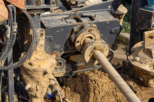 A working horizontal directional drilling machine with a rotating shaft and replaceable robust drill bits. Piping process with torque shaft extension