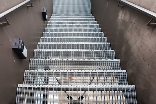 Metal grating staircase leading downwards with handrail