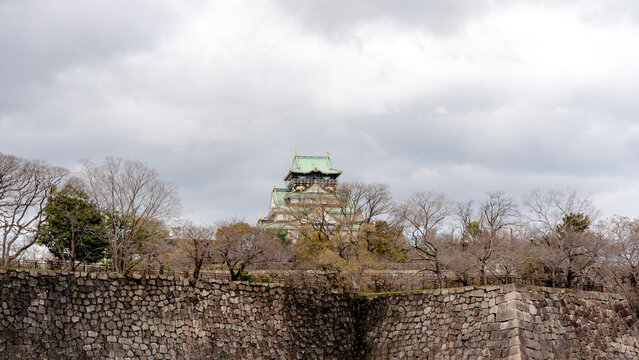 Osaka Castle donjon surrounded by stone walls and trees