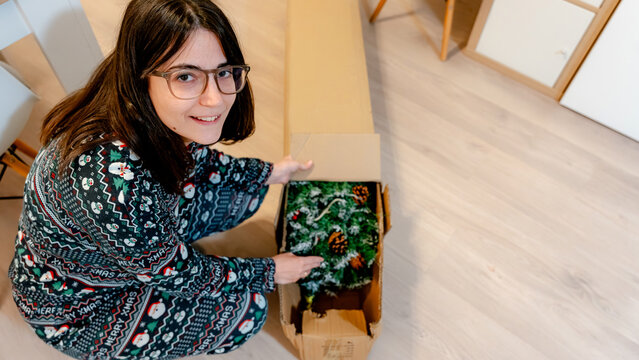 Woman unpacking Christmas tree with joy