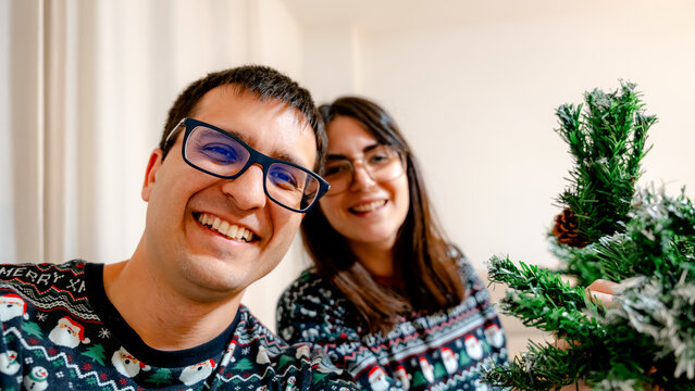 Joyful couple decorating a Christmas tree together