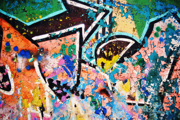 Close-up of colorful urban graffiti fragments on a weathered abandoned wall featuring vibrant spray paint, distressed concrete, grunge texture and street art details. Perfect abstract urban background © djjeep_design