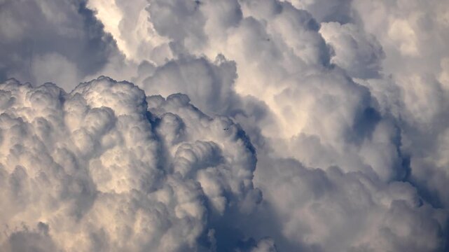 An airplane flying through huge cumulus storm clouds