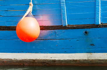 Orange fender against the blue hull of an old wooden boat - 5070 © Wolfgang Jargstorff
