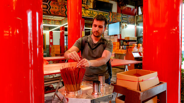 Man placing incense sticks at Sunfong Temple