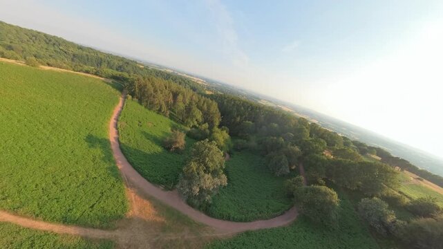 Drone FPV aerial view over a trail path through the English countryside