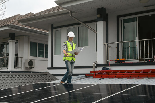 Solar Panel Engineer Inspecting Installation on Residential Home Rooftop with Clipboard