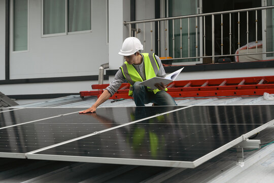 Engineer Inspecting Solar Panel Installation on Residential Rooftop with Clipboard
