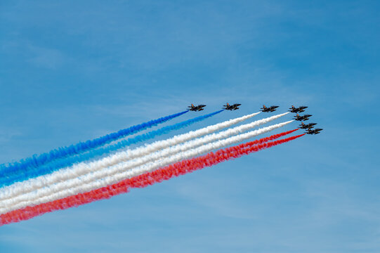Patrouille de France Alpha Jets cross New York sky. Nine aircraft release blue, white and red smoke during the Sail4th 250 aerial review.