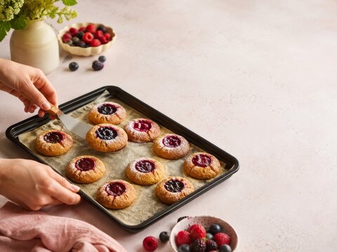 Hornear galletas con bayas en una cocina sencilla y luminosa en la ma&ntilde;ana