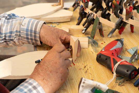 Carpenter assembling wooden piece with tools in Palamos