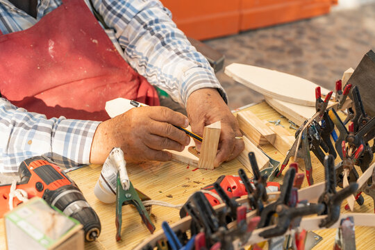 Woodworker crafting a small wooden boat model in Palamos