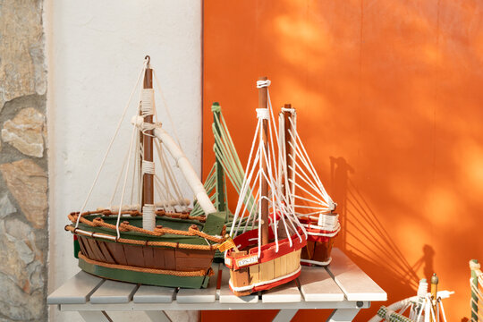Handmade model fishing boats in Palamos against orange wall