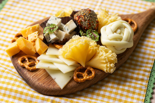 Assorted cheese board with pretzel and herb cheese ball