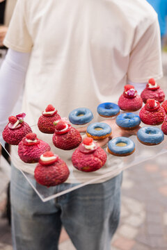 Colorful Mini Desserts Served on Catering Tray
Assorted Party Pastries with Red and Blue Sweets
Waiter Holding Tray with Mini Dessert Appetizers